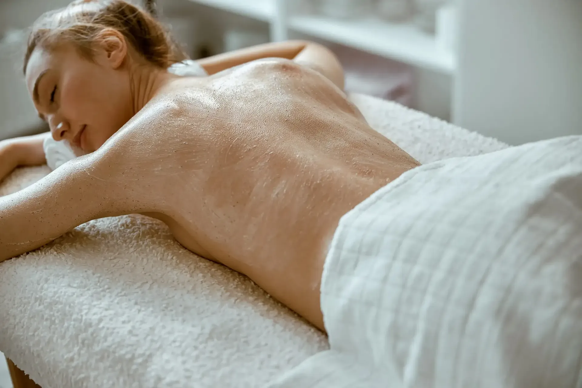 Una persona tumbada boca abajo en una camilla de masaje 