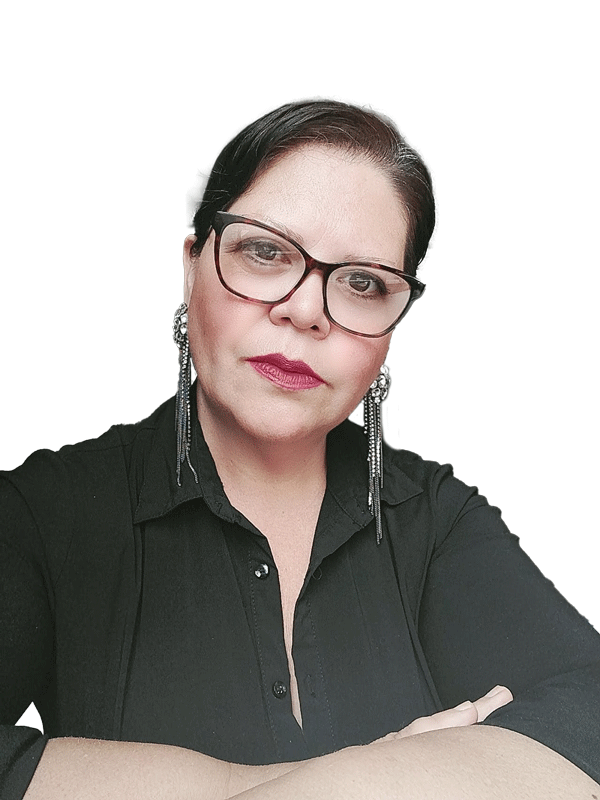 Una mujer que lleva gafas y pendientes está de pie con los brazos cruzados.