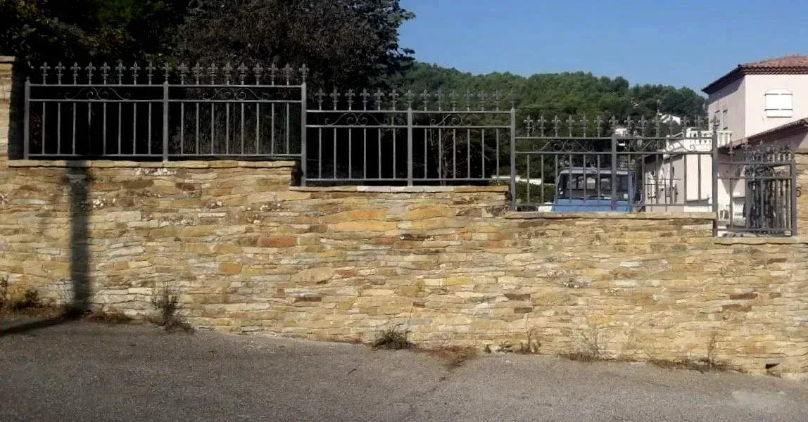 Clôture en acier sur un muret en pierre