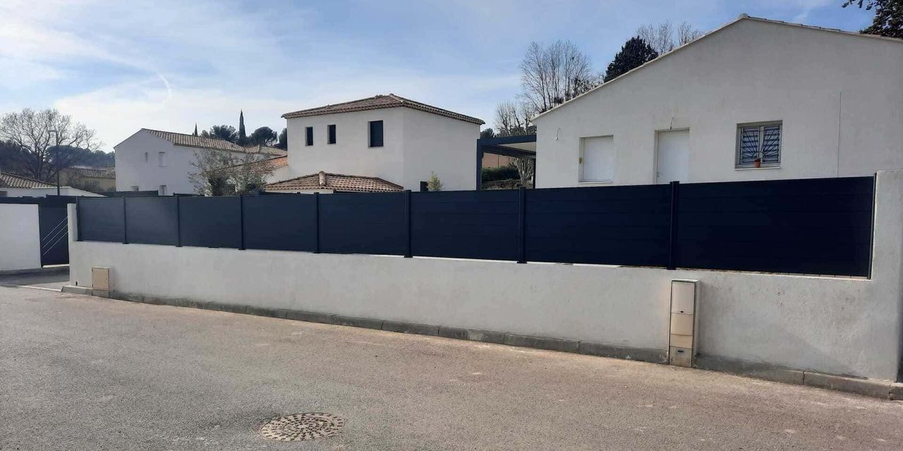 Une clôture noire devant une maison