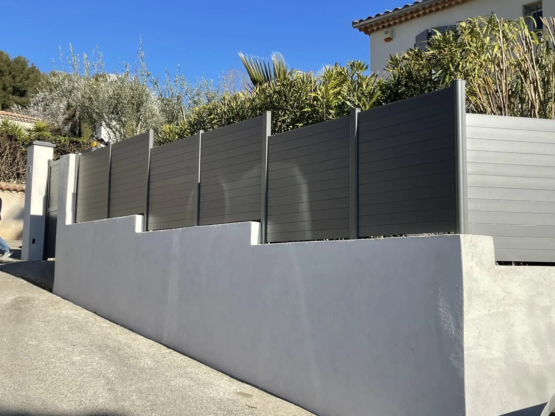Clôture grise sur un muret en béton