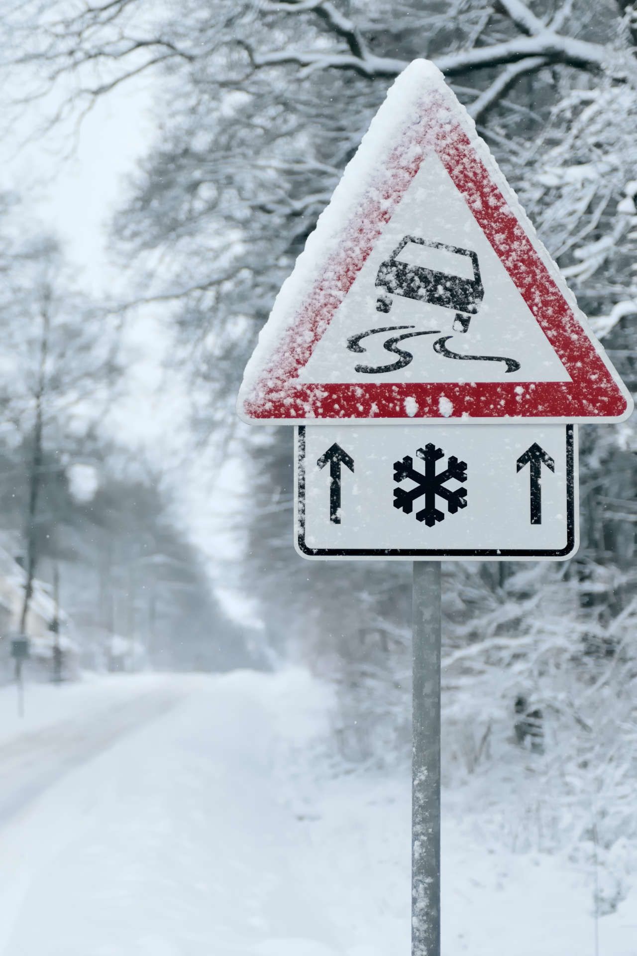 Hinweisschild für Rutschgefahr durch Schnee im Winter