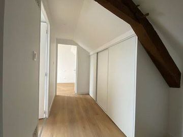Un couloir avec les murs et cloisons blancs.