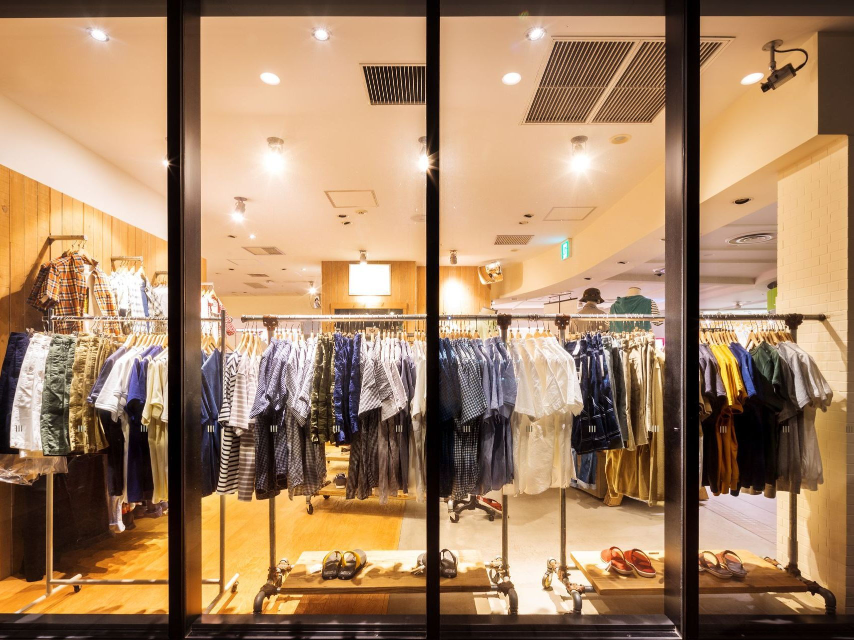 Vitrine de magasin avec des vêtements derrière la vitre. 