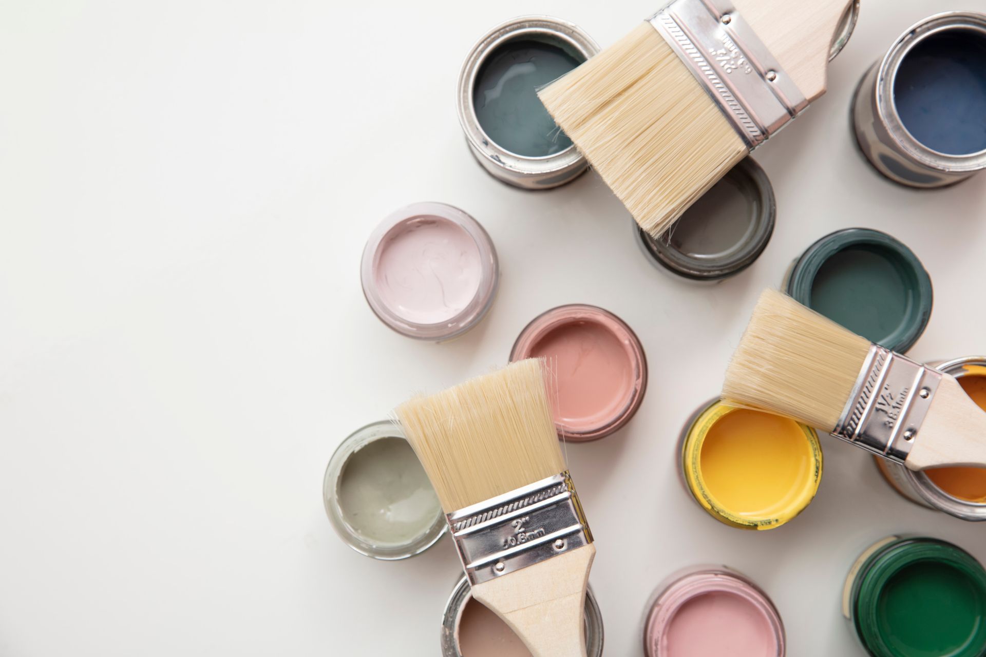 Plusieurs pots de peinture et les pinceaux.