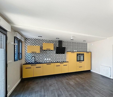 Cuisine avec les meubles en bois et le parquet au sol. 