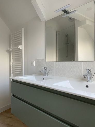 Salle de bains avec un meuble vasque et un miroir.