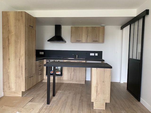 Cuisine avec les meubles en bois et le parquet au sol.