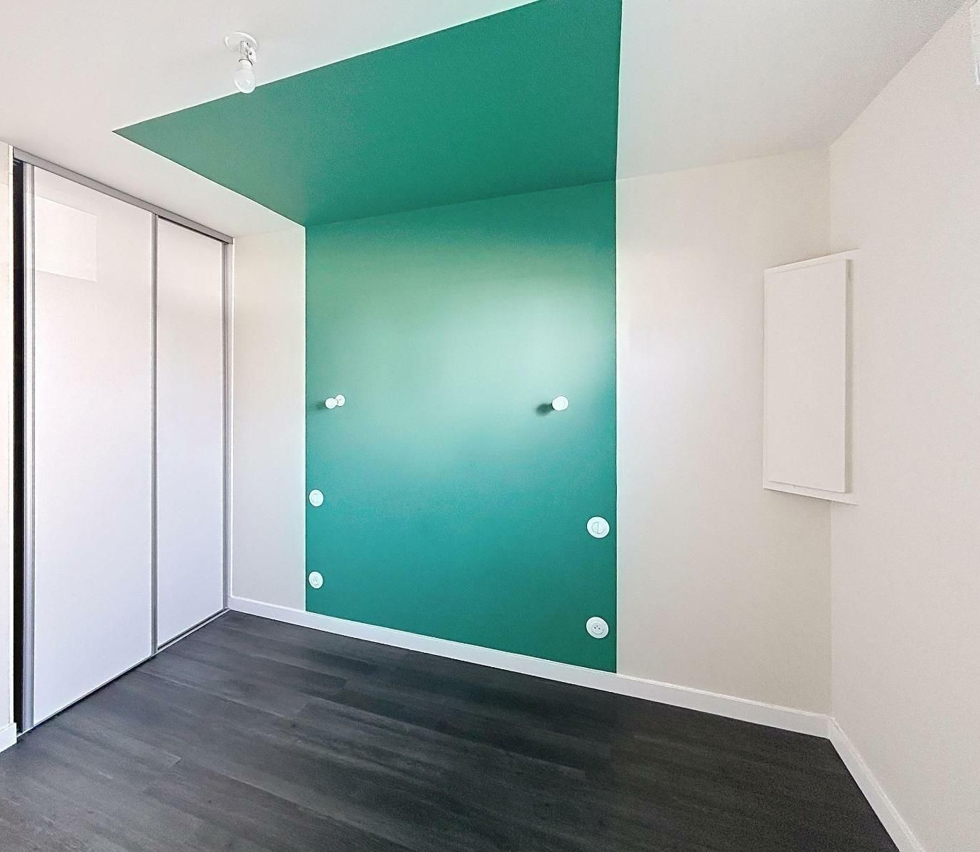 Une pièce de vie avec le dressing encastré et un mur vert.