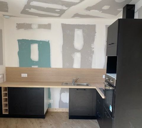 Les meubles de cuisine installés dans une pièce avec les murs en plâtre. 