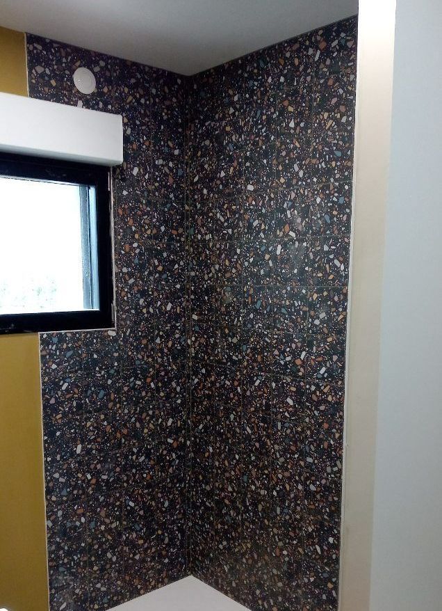 Gros plan sur le carrelage de la cabine de douche.