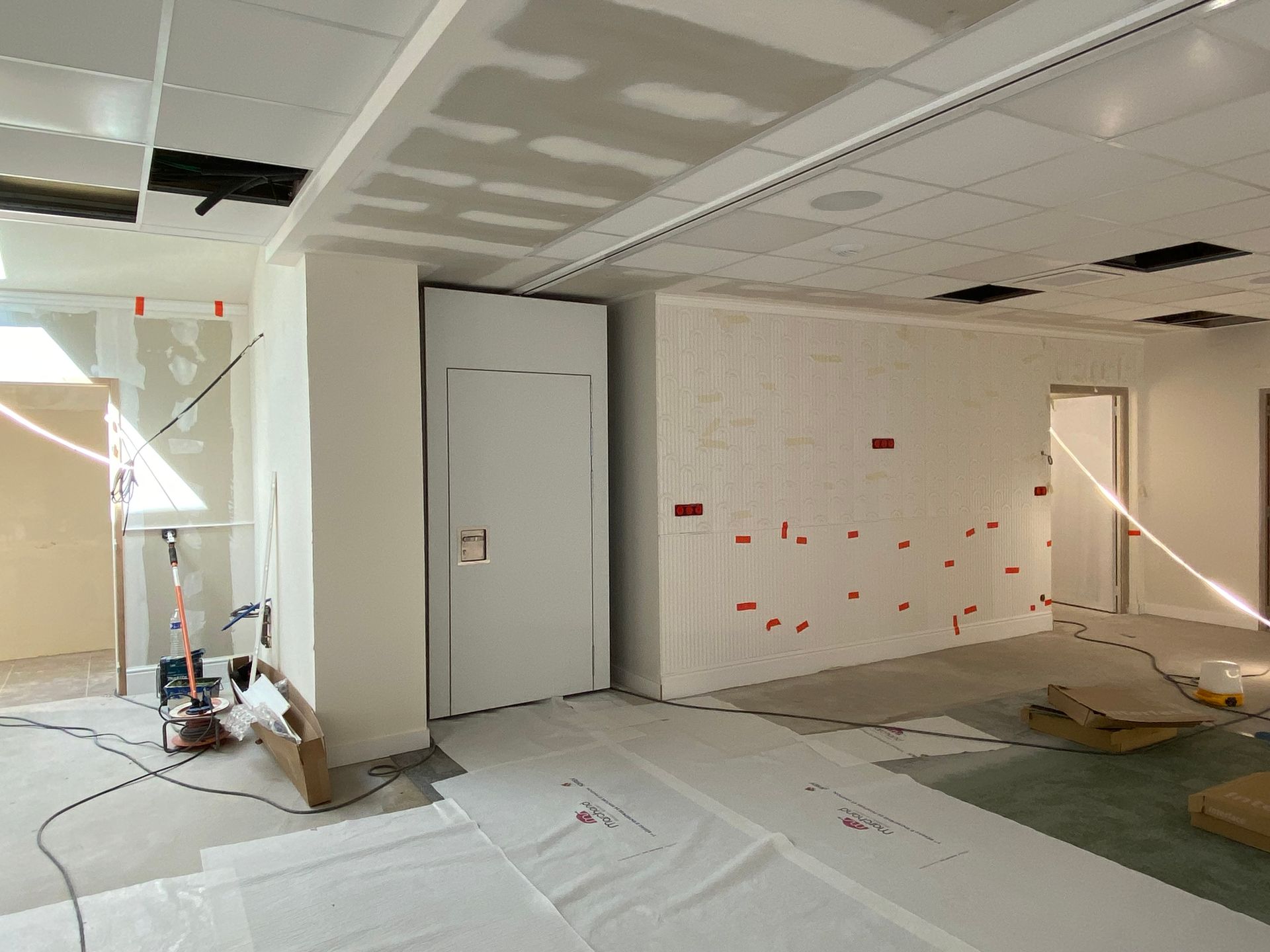 Un espace de travail avec les cloisons en plâtre et le faux plafond. 
