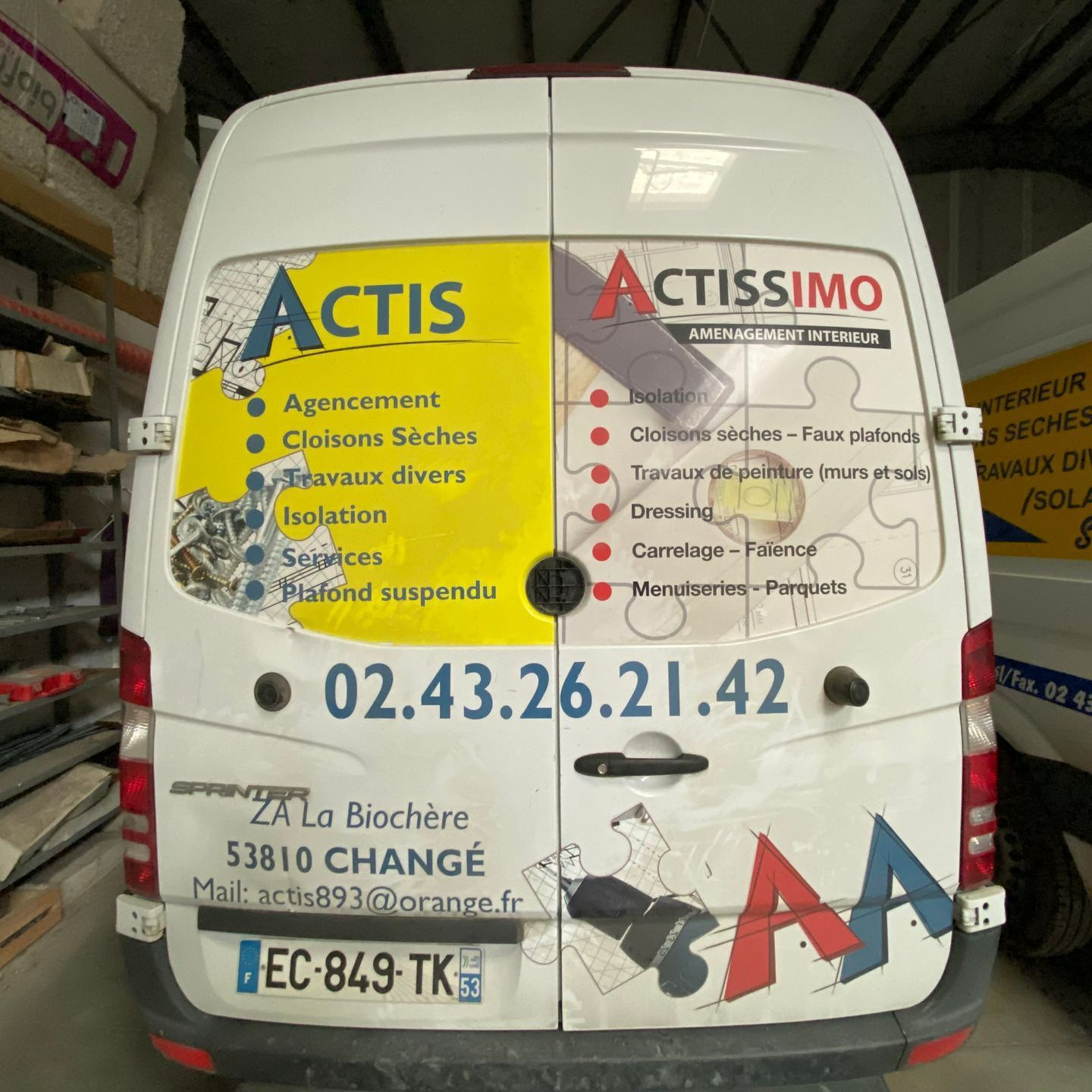 Les portes arrière du camion avec le nom et les prestations de la société. 