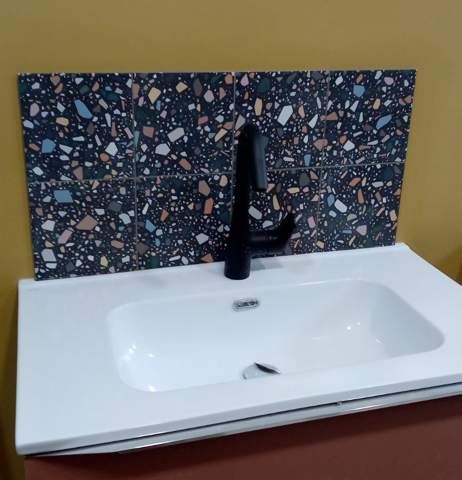 Un meuble vasque avec une crédence en carrelage.