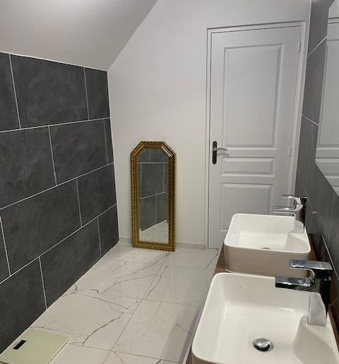 Salle de bains avec une porte et un miroir à côté.