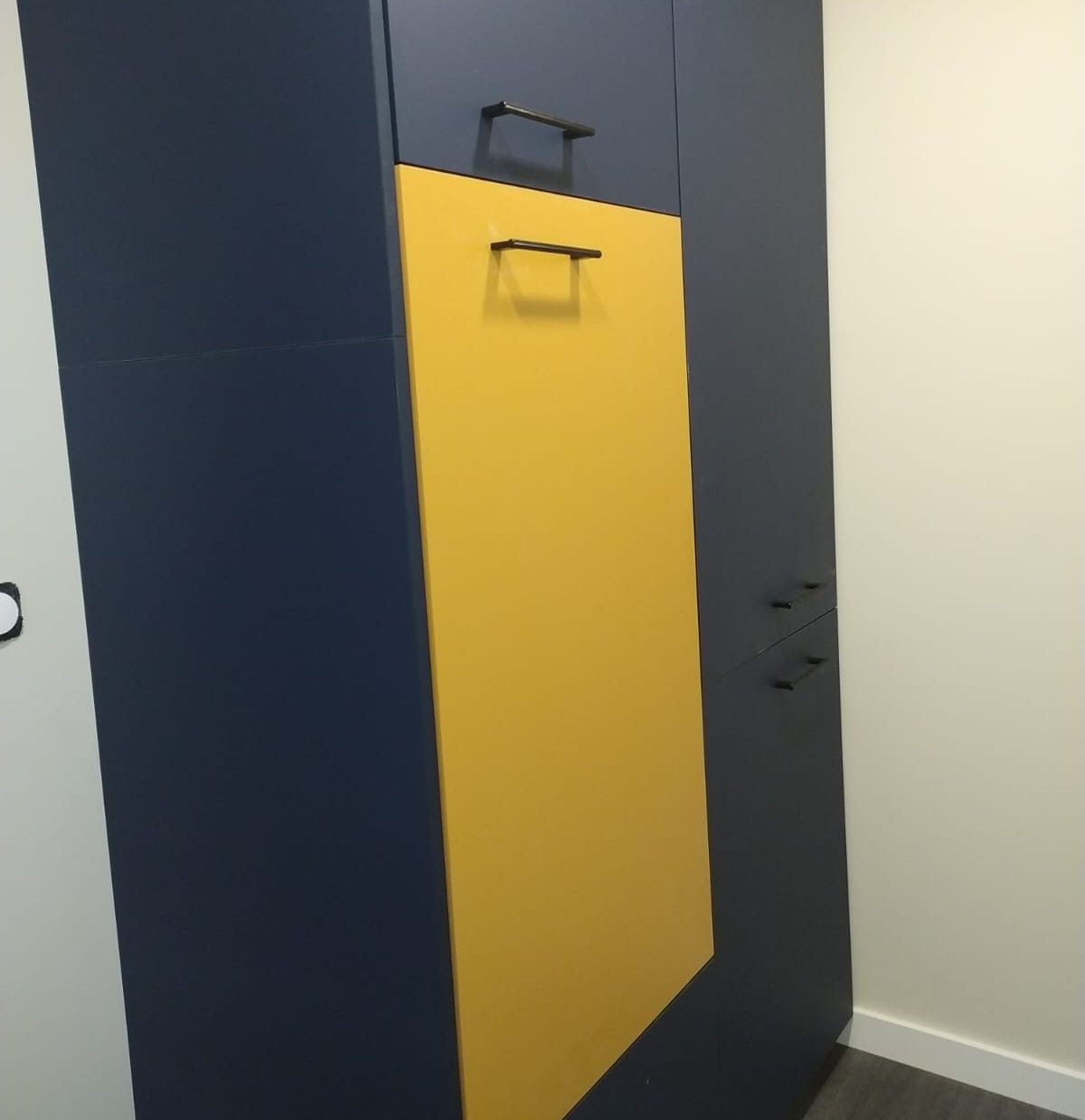 Placard bleu avec une porte jaune.