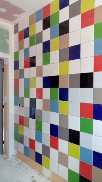 Détail d'un mur avec le carrelage multicolore.