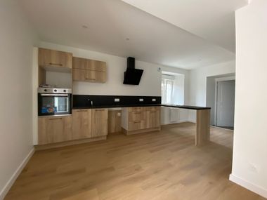 Cuisine avec les meubles en bois et le parquet au sol. 