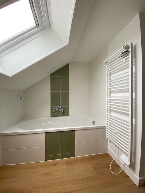 Carrelage blanc et verre sur le mur et l'habillage de la baignoire.