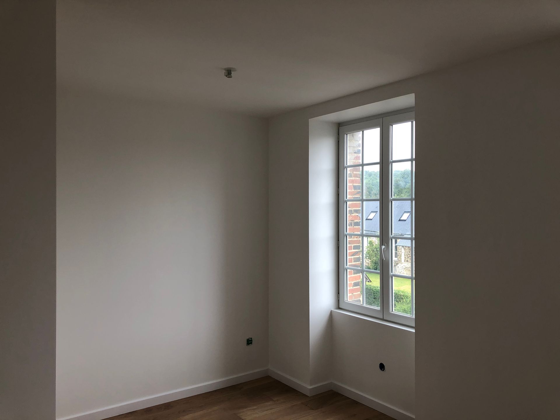 Pièce avec les murs blancs et une fenêtre.