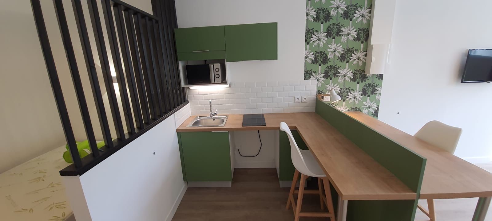 Pièce avec un coin cuisine et la table centrale.