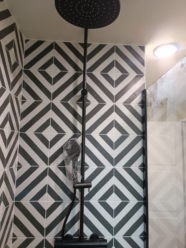 Gros plan sur le carrelage mural dans une cabine de douche.