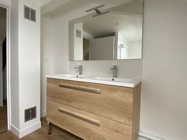 Salle de bains avec un meuble vasque et un miroir.