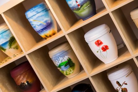 In den Regalen stehen viele verschiedene Urnenarten.