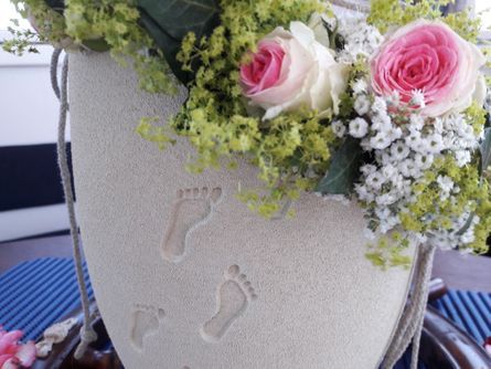 Eine Vase mit Blumen und Fußabdrücken darauf