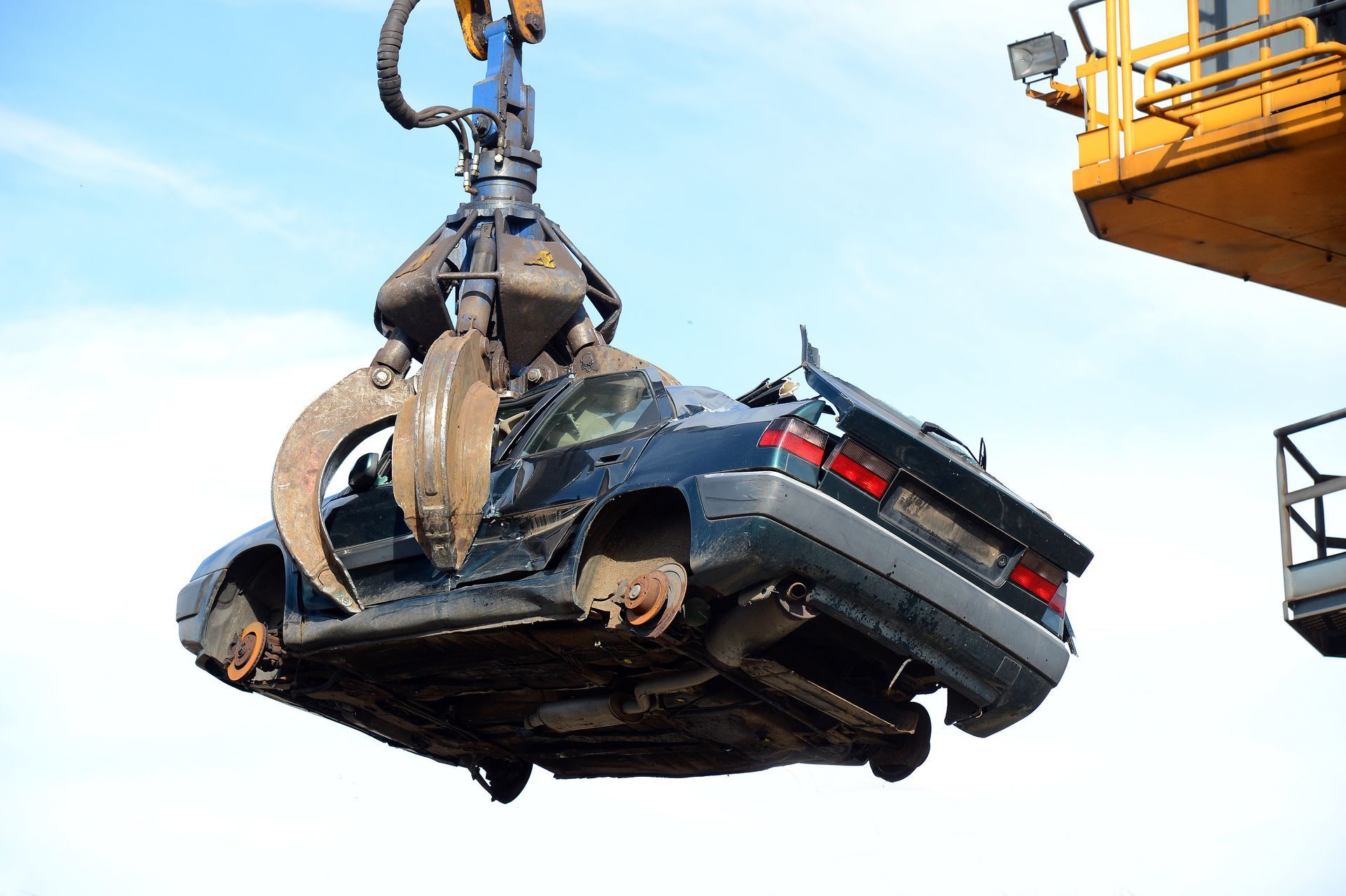 Épave de voiture prise par une pince hydraulique