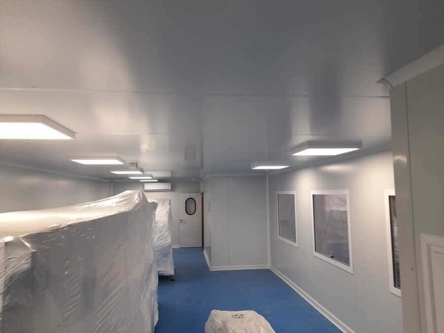 Un pasillo en un edificio con suelo azul y paredes blancas.