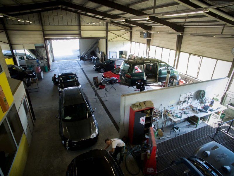 Un homme travaille sur une voiture dans un garage