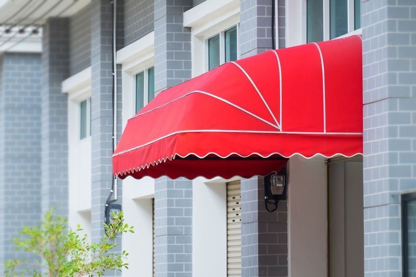 Un toldo rojo está en el costado de un edificio.