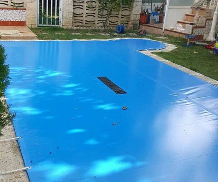 Una gran lona azul cubre una piscina.