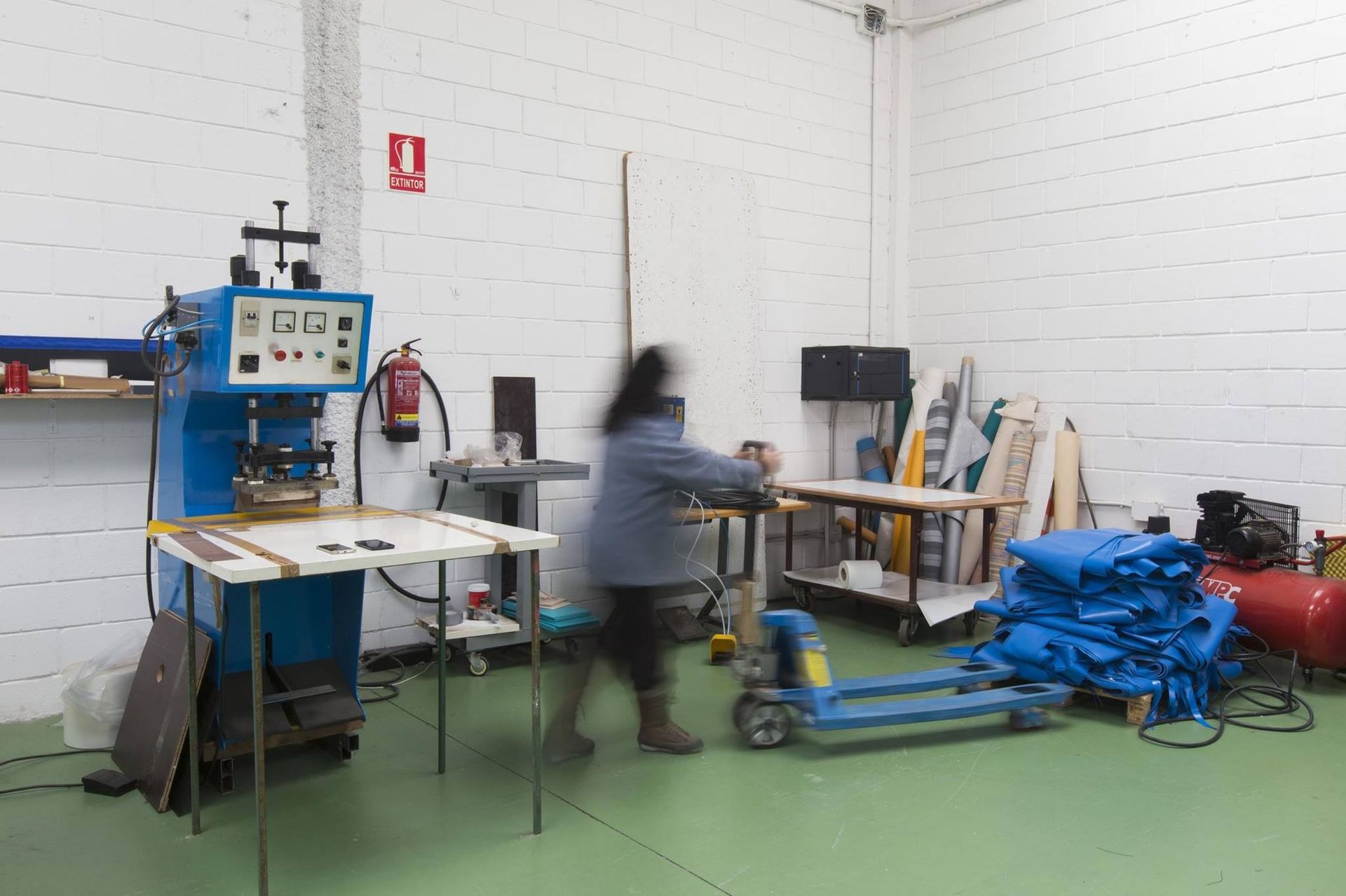 Una mujer camina en una habitación con mucha maquinaria.