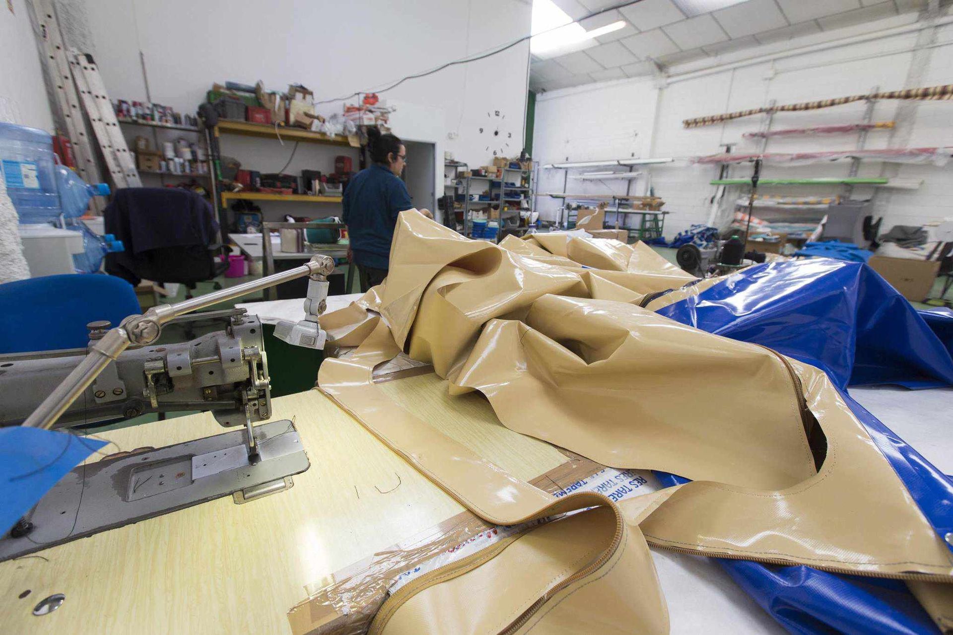 Una máquina de coser está sobre una mesa en una fábrica.