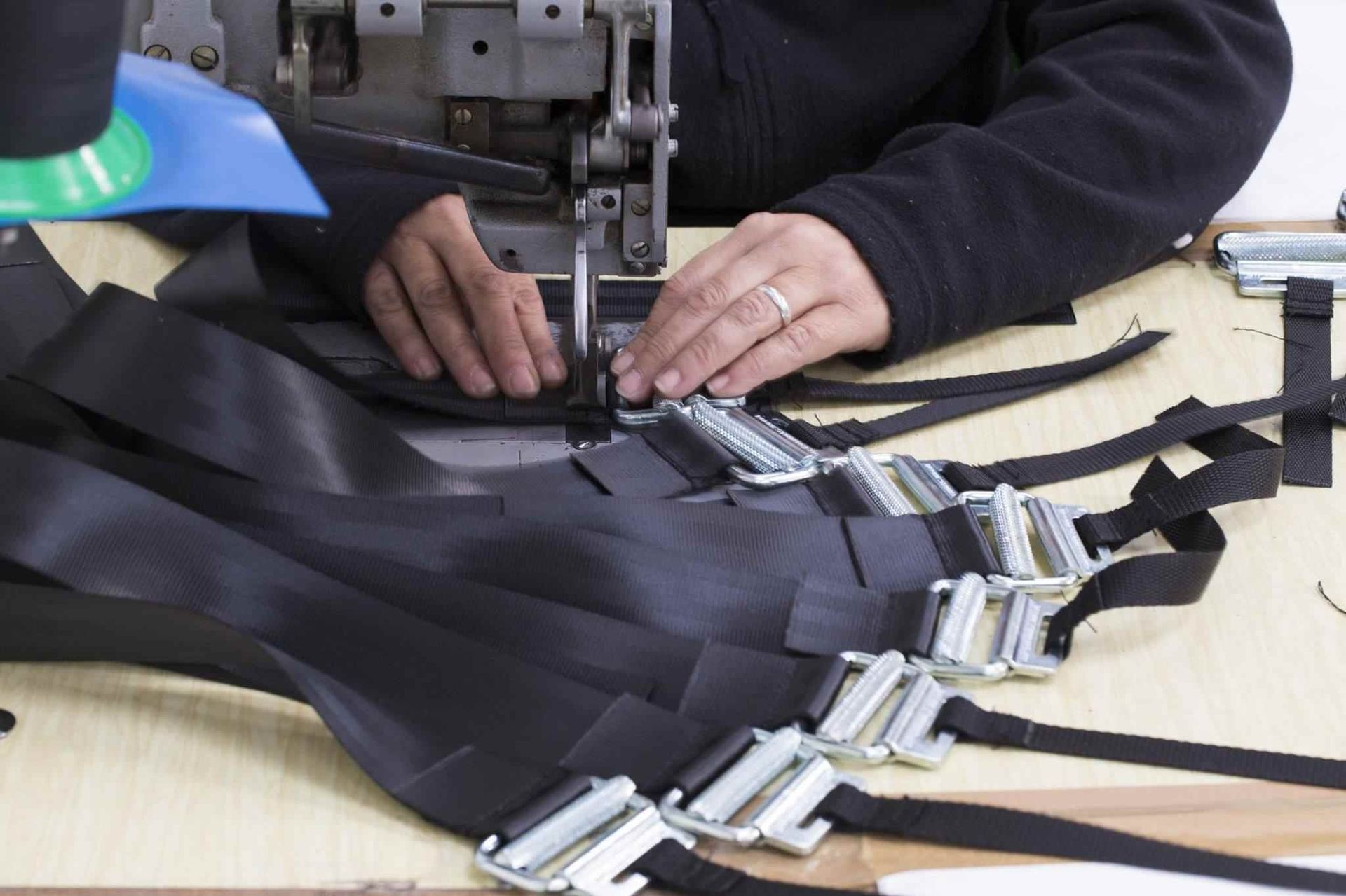 Una persona está usando una máquina de coser para hacer un cinturón.