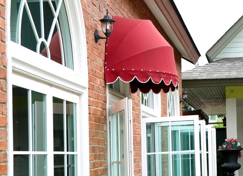 Un toldo rojo está en el costado de un edificio de ladrillos.