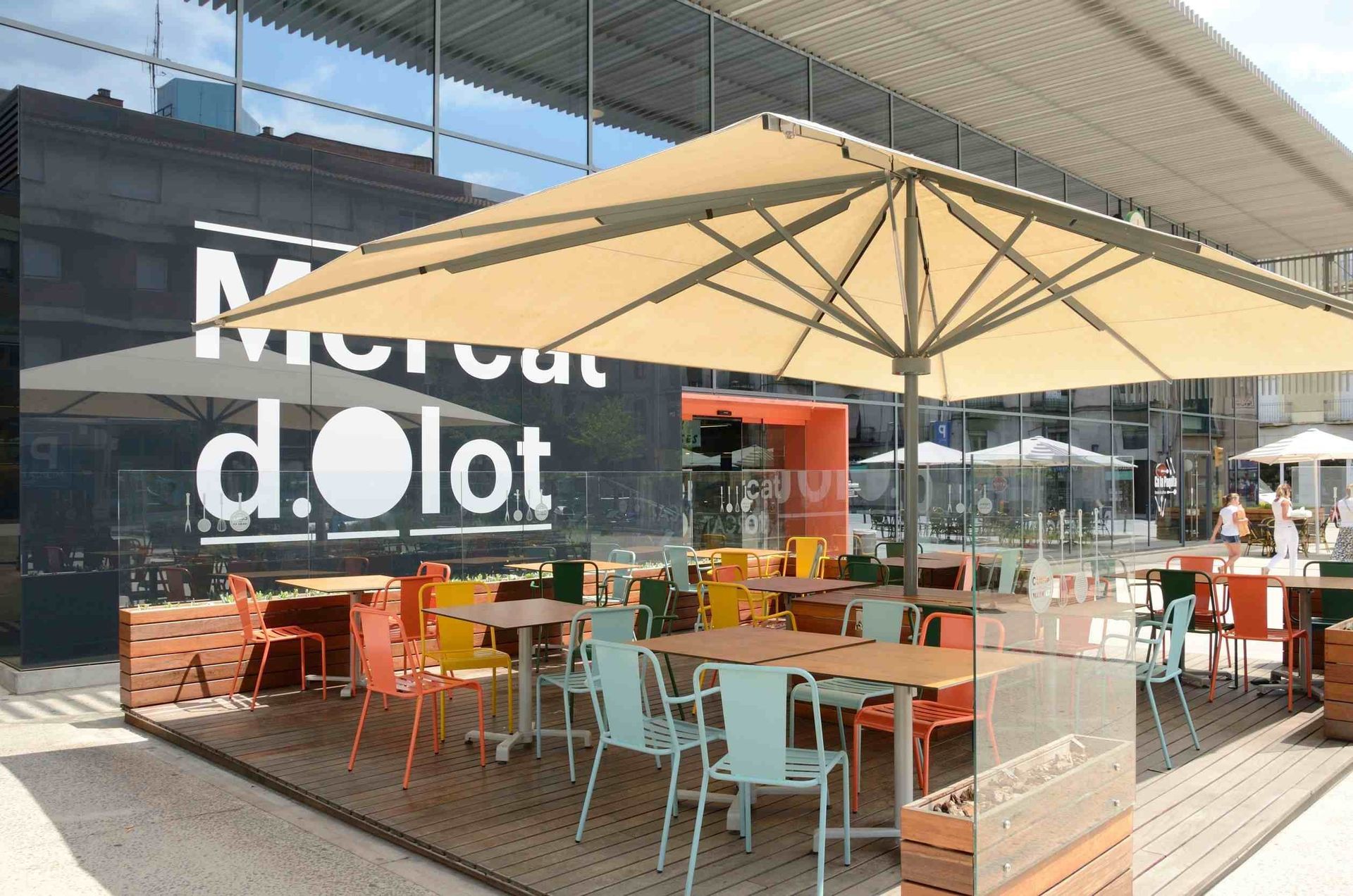 Un restaurante con mesas, sillas y sombrillas al aire libre.