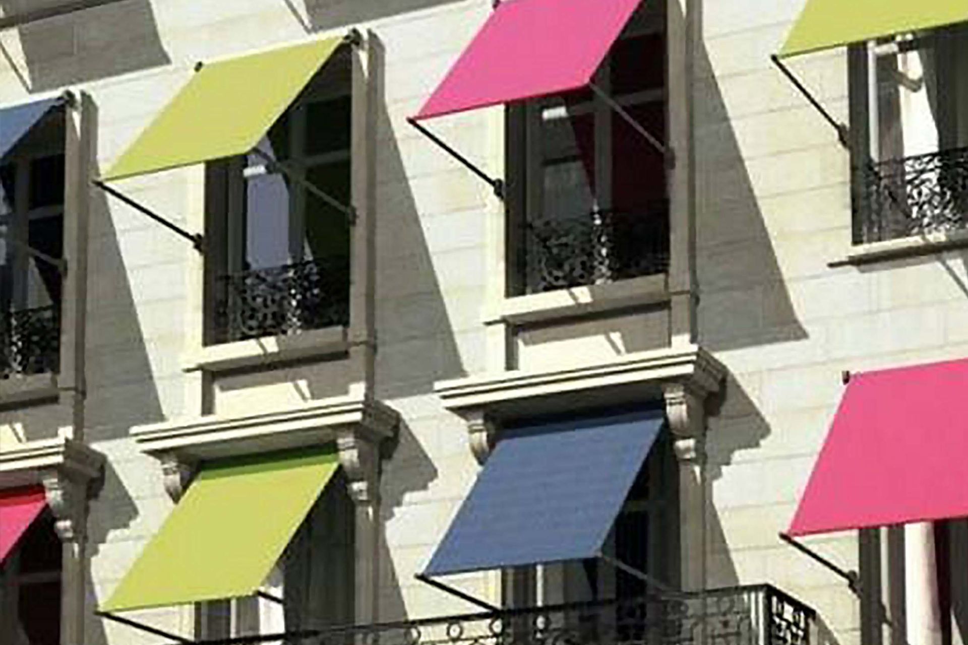 Un edificio con toldos de colores en las ventanas.