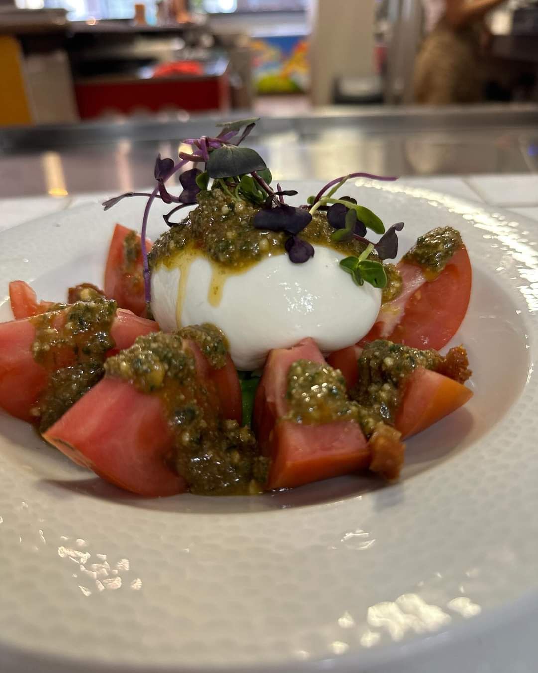 Un plato blanco cubierto con tomates y un huevo escalfado.