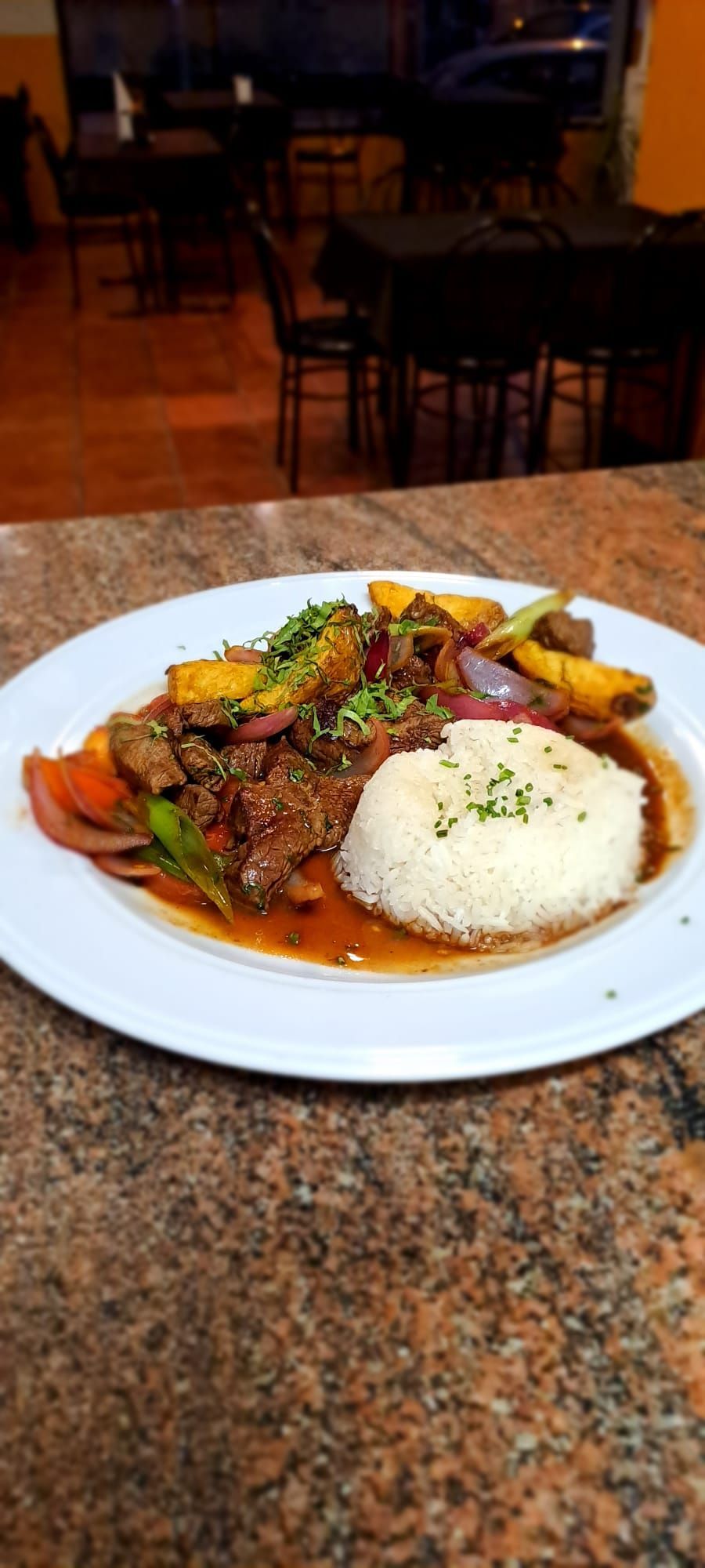 Un plato de comida con arroz y verduras en una mesa.