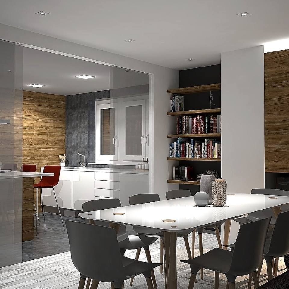 Un comedor con mesa blanca y sillas grises, que cuenta con una estantería y vistas a una cocina moderna