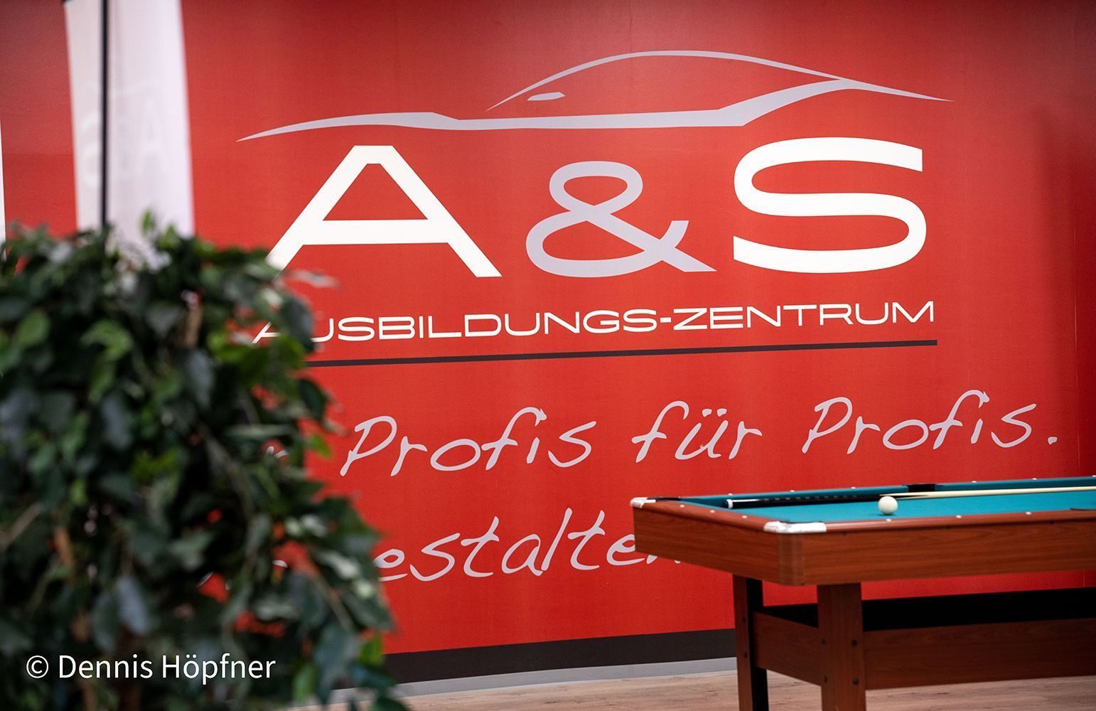 Ein Billardtisch vor einem Schild mit der Aufschrift A & S