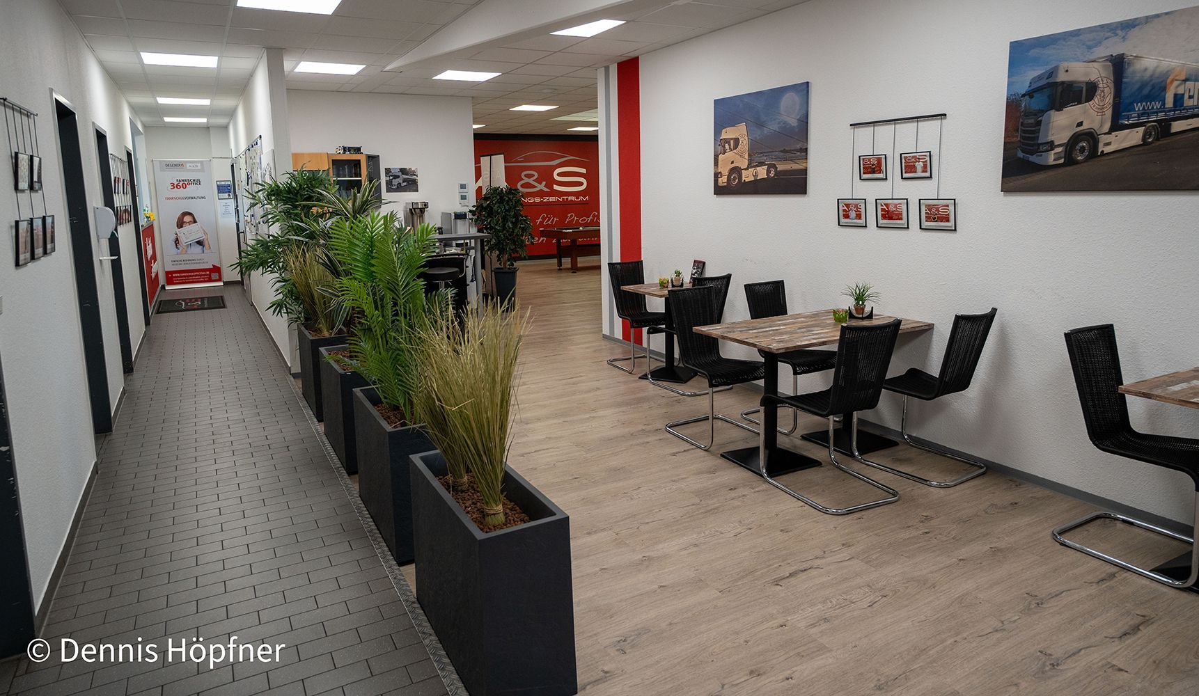 Ein langer Flur mit Tischen und Stühlen in einem Restaurant.