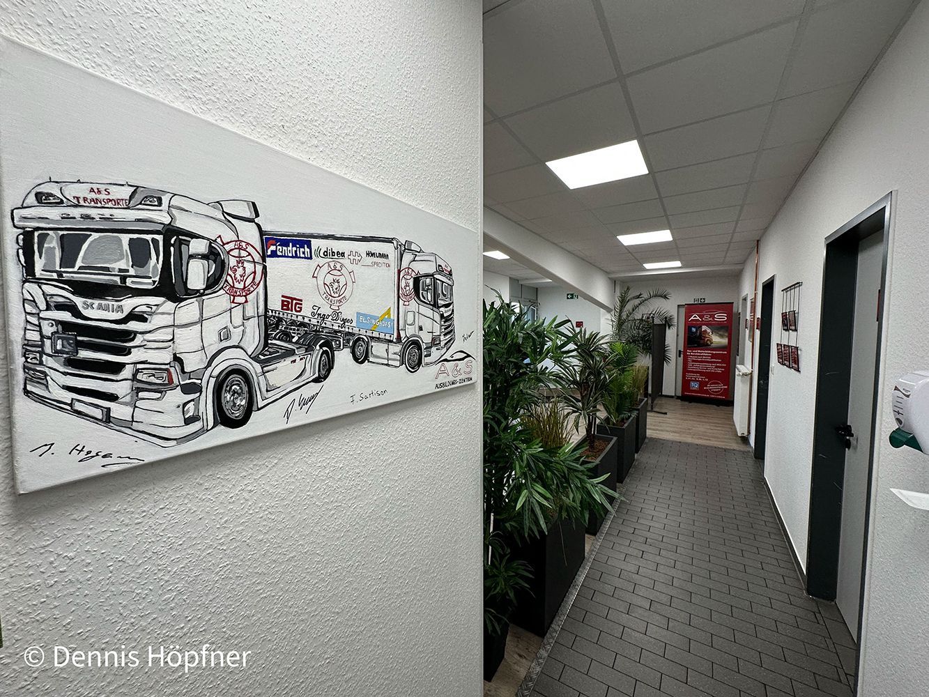 Ein langer Flur mit einem LKW-Gemälde an der Wand.