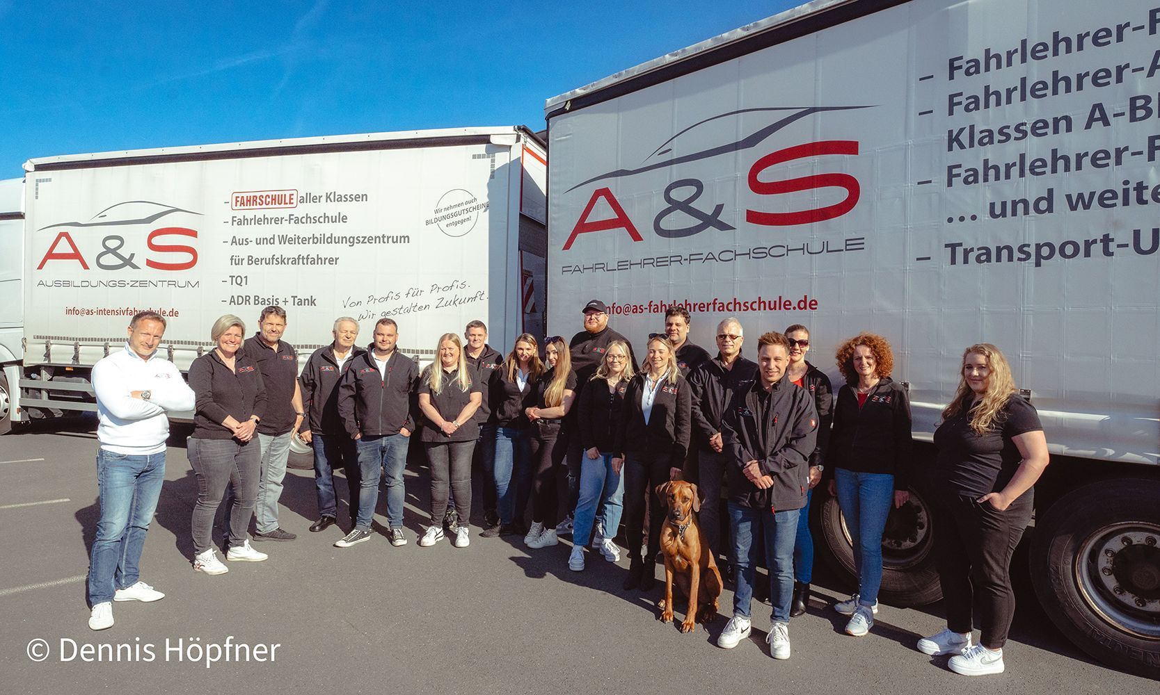 Eine Gruppe von Menschen steht vor einem LKW mit der Aufschrift A & S