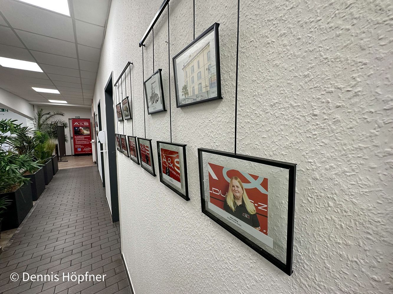 Ein Flur mit vielen Bildern an der Wand.