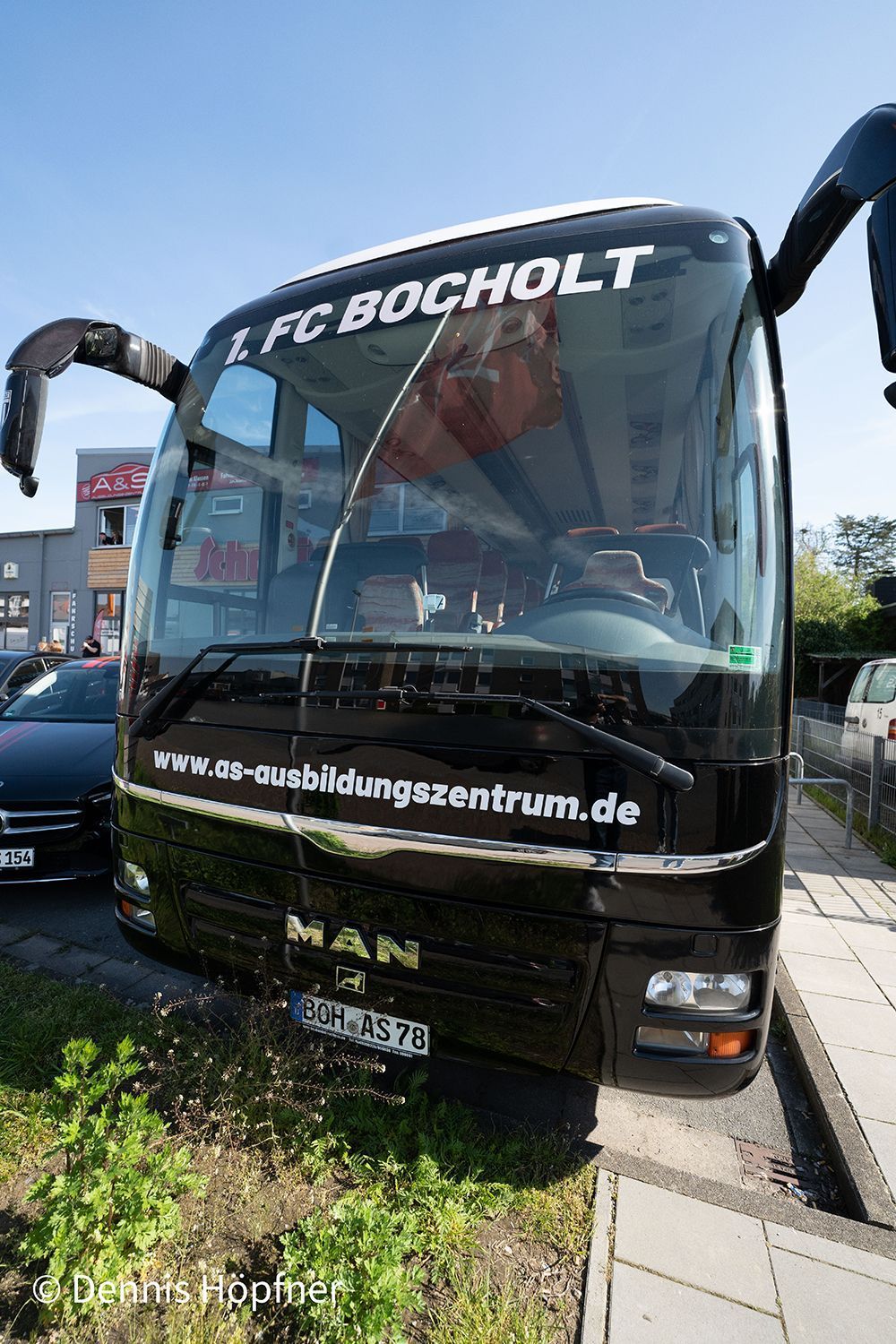 Ein schwarzer Bus parkt am Straßenrand.