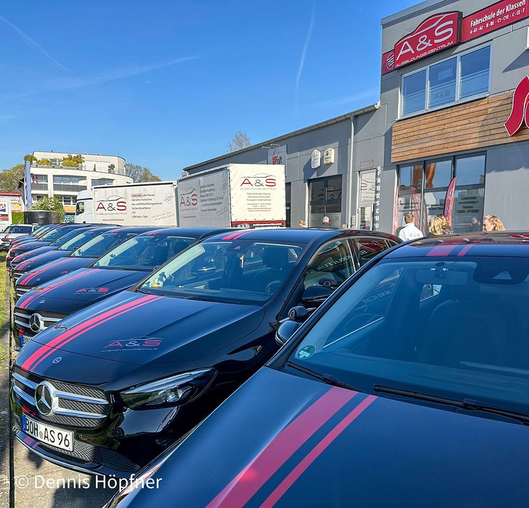 Eine Reihe schwarzer Autos, die vor einem Gebäude parken